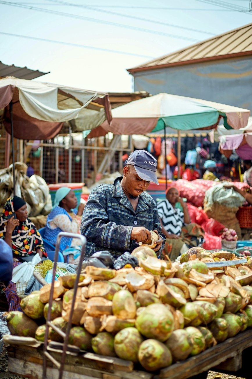 A coconut vendor at a roadside stall in Accra